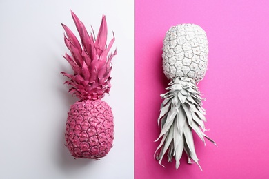 Photo of Pink and white pineapples on color background, flat lay. Creative concept
