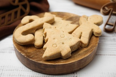 Baked Christmas biscuits of different shapes on white wooden table, closeup