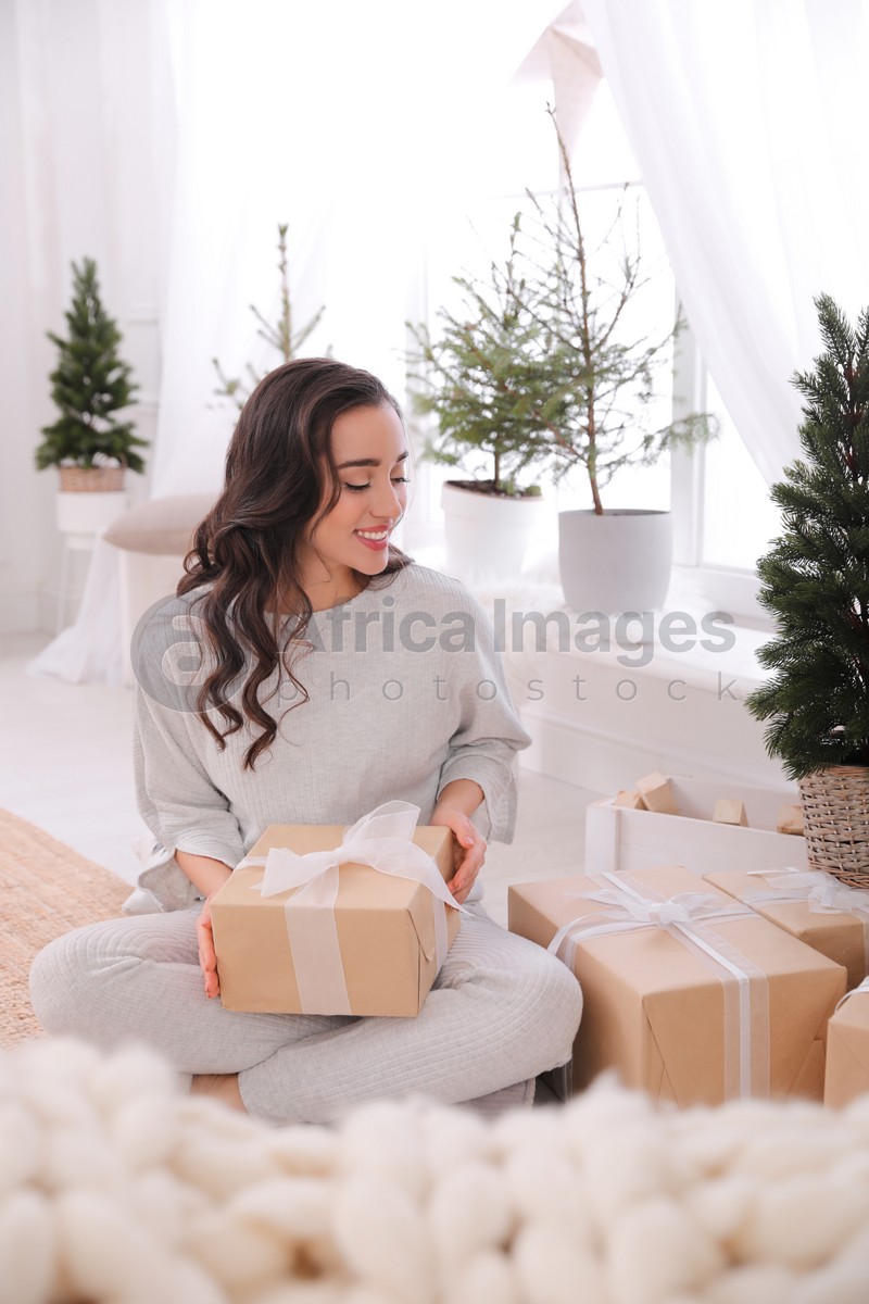 Woman with gift boxes on floor at home