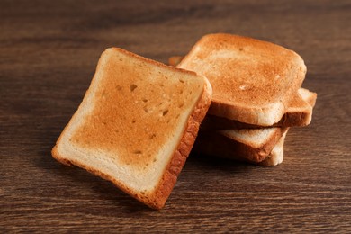 Photo of Slices of delicious toasted bread on wooden table