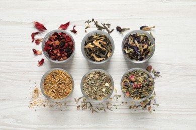 Photo of Flat lay composition with different dry teas on white wooden table
