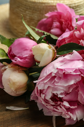 Beautiful fragrant peonies on wooden table, closeup