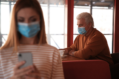 Senior man with medical mask in cafe. Virus protection