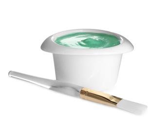 Photo of Freshly made spirulina facial mask in bowl and brush on white background