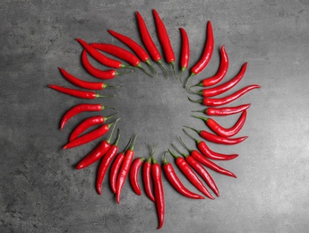 Flat lay composition with chili peppers on grey background