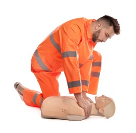 Paramedic in uniform practicing first aid on mannequin against white background