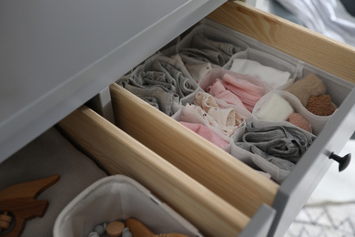 Open cabinet drawer with clothes in child room