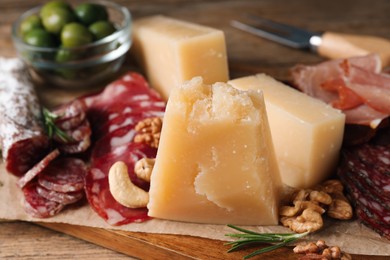 Photo of Snack platter with parmesan cheese on wooden table, closeup