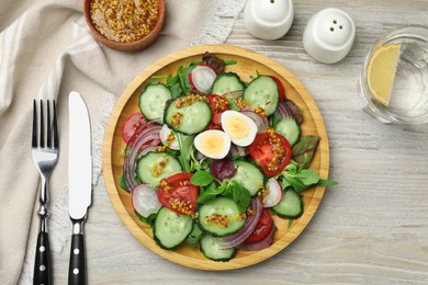 Tasty salad with vegetables and quail eggs on wooden table, flat lay