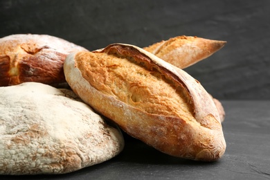 Different kinds of fresh bread on black table