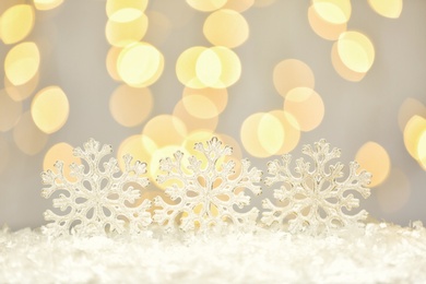 Beautiful decorative snowflakes against blurred festive lights