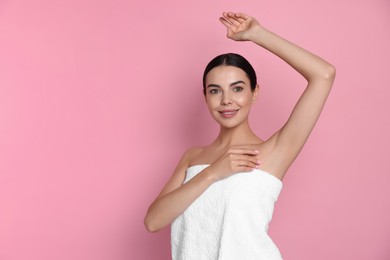 Young woman showing smooth skin after epilation on pink background, space for text