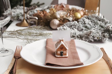 Photo of Luxury festive place setting with blank card and beautiful decor for Christmas dinner on white table indoors