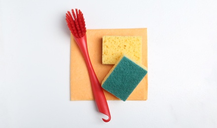 Cleaning supplies for dish washing on white background, top view