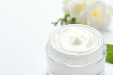 Jar of cream and flowers on white background. Professional cosmetic products