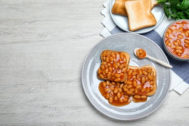 Toasts with delicious canned beans on white wooden table, flat lay. Space for text