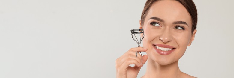 Image of Woman with eyelash curler on white background, space for text. Banner design