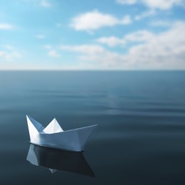 White paper boat floating on calm sea 