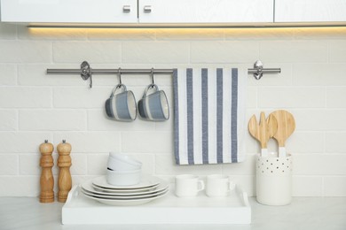 Photo of Clean towel, utensils and dishware in kitchen