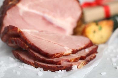 Photo of Cut delicious ham with salt on table, closeup