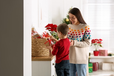 Mother and son with Christmas gifts at home. Advent calendar in basket