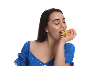 Beautiful young woman eating French fries on white background
