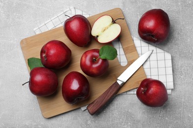 Fresh ripe red apples and knife on light grey table, flat lay