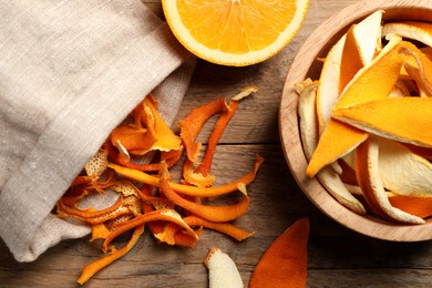 Photo of Dry orange peels and fresh fruit on wooden table, flat lay