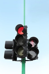 Traffic lights with red signals against blue sky