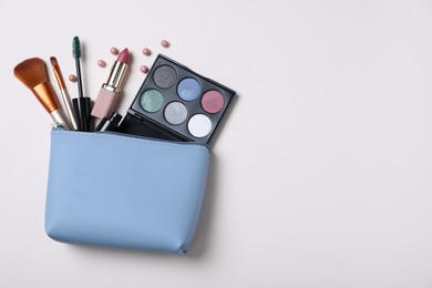 Photo of Cosmetic bag with makeup products and accessories on white background, top view