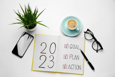 Flat lay composition of notebook with text 2023 Goal, Plan, Action on white background. New year resolutions