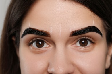 Woman during eyebrow tinting procedure, closeup view
