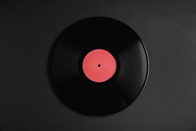 Vintage vinyl record on black background, top view