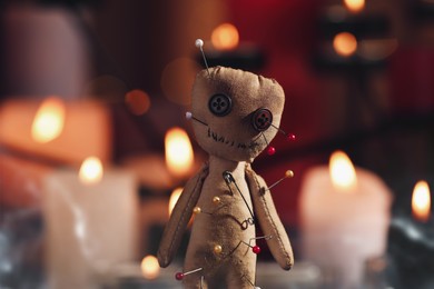 Voodoo doll pierced with pins in dark room, closeup. Curse ceremony