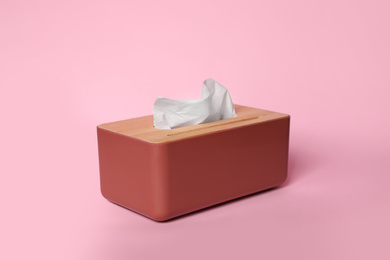 Holder with paper tissues on pink background
