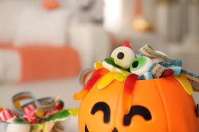 Halloween trick or treat bucket with different sweets indoors, closeup