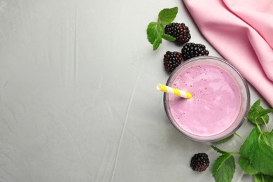 Delicious blackberry smoothie in glass and berries on white table, flat lay. Space for text