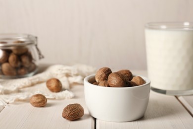 Nutmegs in bowl on white wooden table