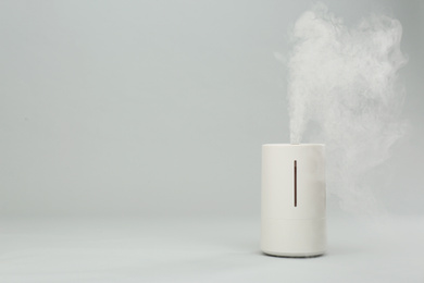 Modern air humidifier on light grey background. Space for text