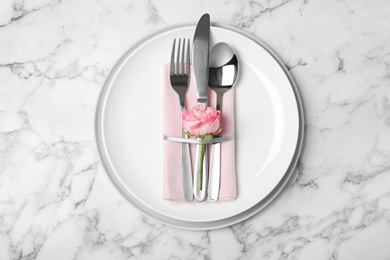 Beautiful table setting with cutlery, napkin and plates on marble background, top view