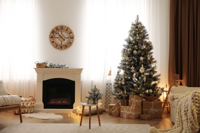 Beautiful living room interior with decorated Christmas tree and modern fireplace