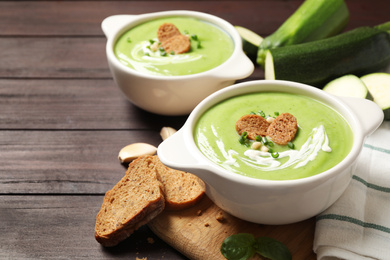 Tasty homemade zucchini cream soup served on wooden table