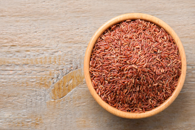 Brown rice on wooden table, top view. Space for text