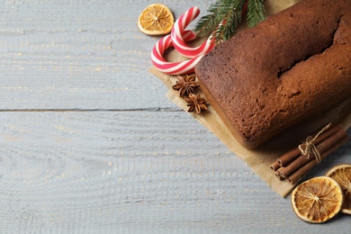 Delicious gingerbread cake, ingredients and Christmas items on wooden table, flat lay. Space for text