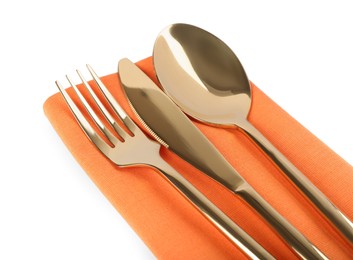 Photo of Orange napkin with golden cutlery on white background, closeup