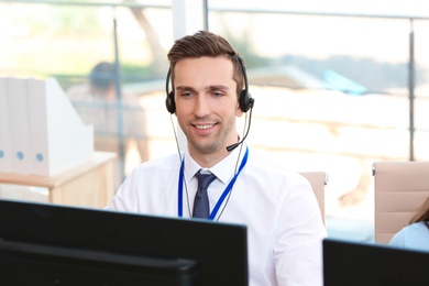 Male technical support operator with headset at workplace
