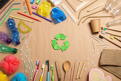 Recycling symbol and household goods on beige background, flat lay