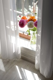 Bouquet of beautiful bright ranunculus flowers in glass vase indoors