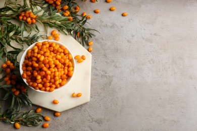 Fresh ripe sea buckthorn on grey table, flat lay. Space for text
