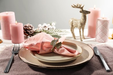 Stylish table setting with pink fabric napkin, beautiful decorative ring and festive decor on white background